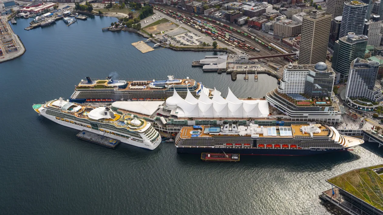 Three cruise ships are berthed around the Canada Place cruise terminal, seen from above
